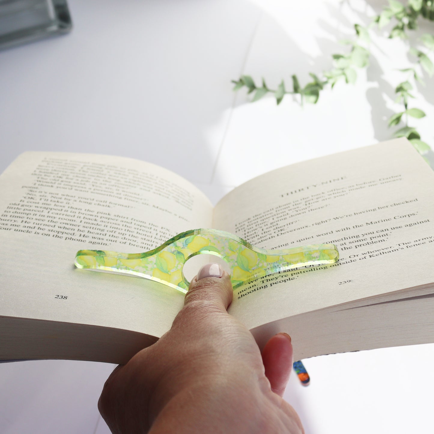 clear acrylic printed thumb holder for keeping pages open on a book with one hand