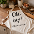 Personalised 'Oh Crepe!' apron with 'Kathryn's cooking' on a wooden kitchen worktop
