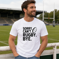 White rugby t-shirt printed with 'Sorry. Can't. Rugby. Bye.' and a rugby ball, worn pitchside