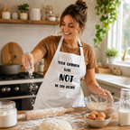 White apron with 'Your opinion was not in the recipe' slogan, worn by a woman baking