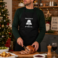Black Christmas apron with white 'Merry Force Be With You' slogan and a sci-fi helmet design, worn carving a roast