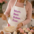 Cream personalised apron with 'Mum. Best. Baker. Ever.' in pink, worn while baking