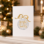 'Jingle Bells' Christmas card with a gold foil bauble design, styled with festive decorations