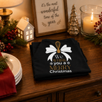 Black Christmas cooks apron with festive whisk slogan, worn in a kitchen setting