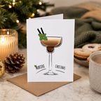 Espresso martini Christmas card propped beside festive decorations