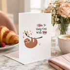 Sloth Valentine's card with hearts, held up beside flowers