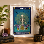 Framed tarot style print 'The Zero Fucks Given' with seated skeleton and mandala, on a shelf