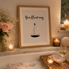 Black and white 'You Float My' sailboat print in a black frame