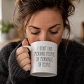 White mug reading 'I don't like morning people, or mornings, or people', held while drinking