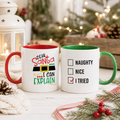 Two Christmas mugs, one 'Dear Santa I Can Explain' with red handle, one naughty nice checklist with green handle