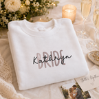 White personalised bride sweatshirt with 'Bride' in rose gold and 'Kathryn' in black script