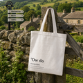 Cotton tote bag printed with an ''Ow do' dictionary definition, hung on a Yorkshire Dales gate