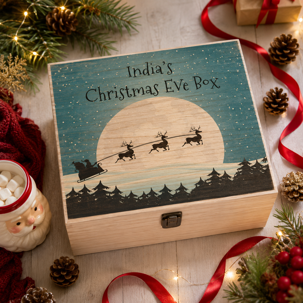 Personalised wooden Christmas Eve box with a festive sleigh scene, styled with garland and baubles