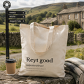 Cotton tote bag printed with a 'Reyt good' dictionary definition, on a wall in the Dales
