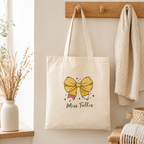 Personalised teacher tote bag with pencil bow design on a desk setting