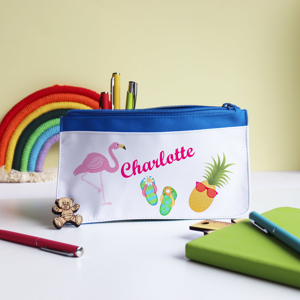 A personalized blue pencil case with white text, featuring a flamingo, pineapple, and eraser illustrations, with 'Charlotte' printed on the front.