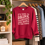 Burgundy slogan sweatshirt hanging on a clothes rail next to a leopard print jacket and denim, styled shot on a wooden hanger.