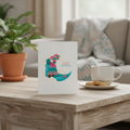 Eid Mubarak card on a table with a cup of tea and cookies in a cozy living room.