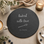 Engraved slate baking board displayed with strawberries, eggs, flour and baking accessories.