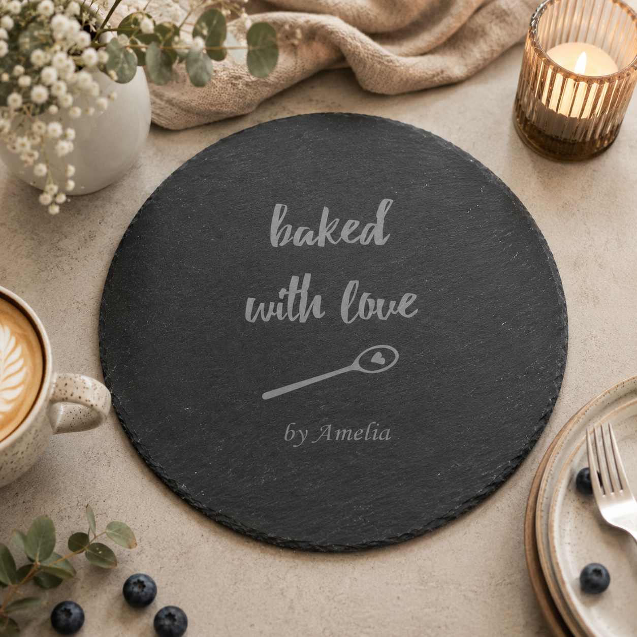 Engraved slate baking board displayed with strawberries, eggs, flour and baking accessories.