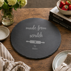 Engraved slate baking board featuring a rolling pin design, styled with eggs and baking accessories.