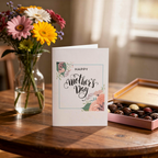 Mother's Day card with flowers and chocolates on a wooden table