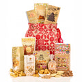 Festive Favourites Gift Bag Hamper with fudge, a chocolate Christmas tree bar, gingerbread popcorn and shortbread by a red drawstring bag