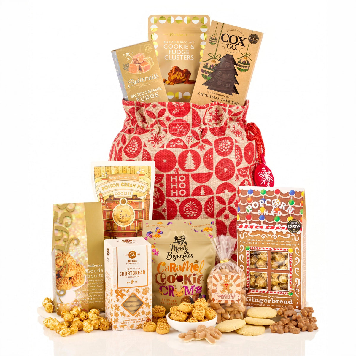 Festive Favourites Gift Bag Hamper with fudge, a chocolate Christmas tree bar, gingerbread popcorn and shortbread by a red drawstring bag