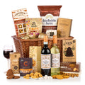 A Cosy Christmas Hamper with La Deliziosa red and white wine, popcorn, crisps, wafer rolls and shortbread in a wicker basket