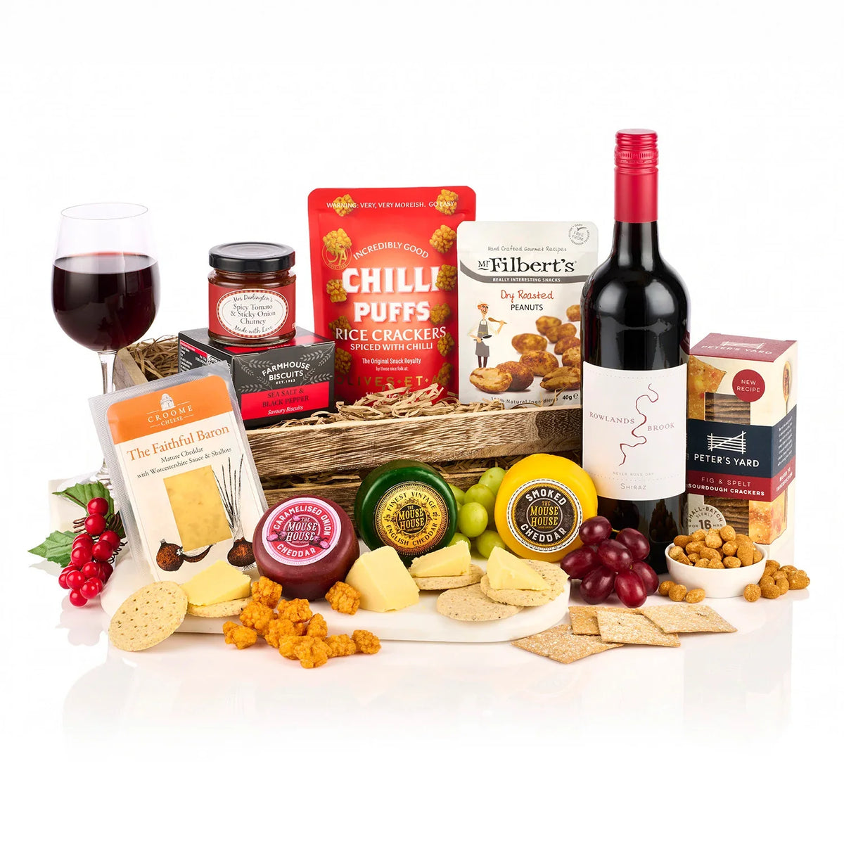 The Decadent Deli Hamper with a bottle of Rowlands Brook Shiraz, four cheddars, crackers, chutney and peanuts in a woven basket