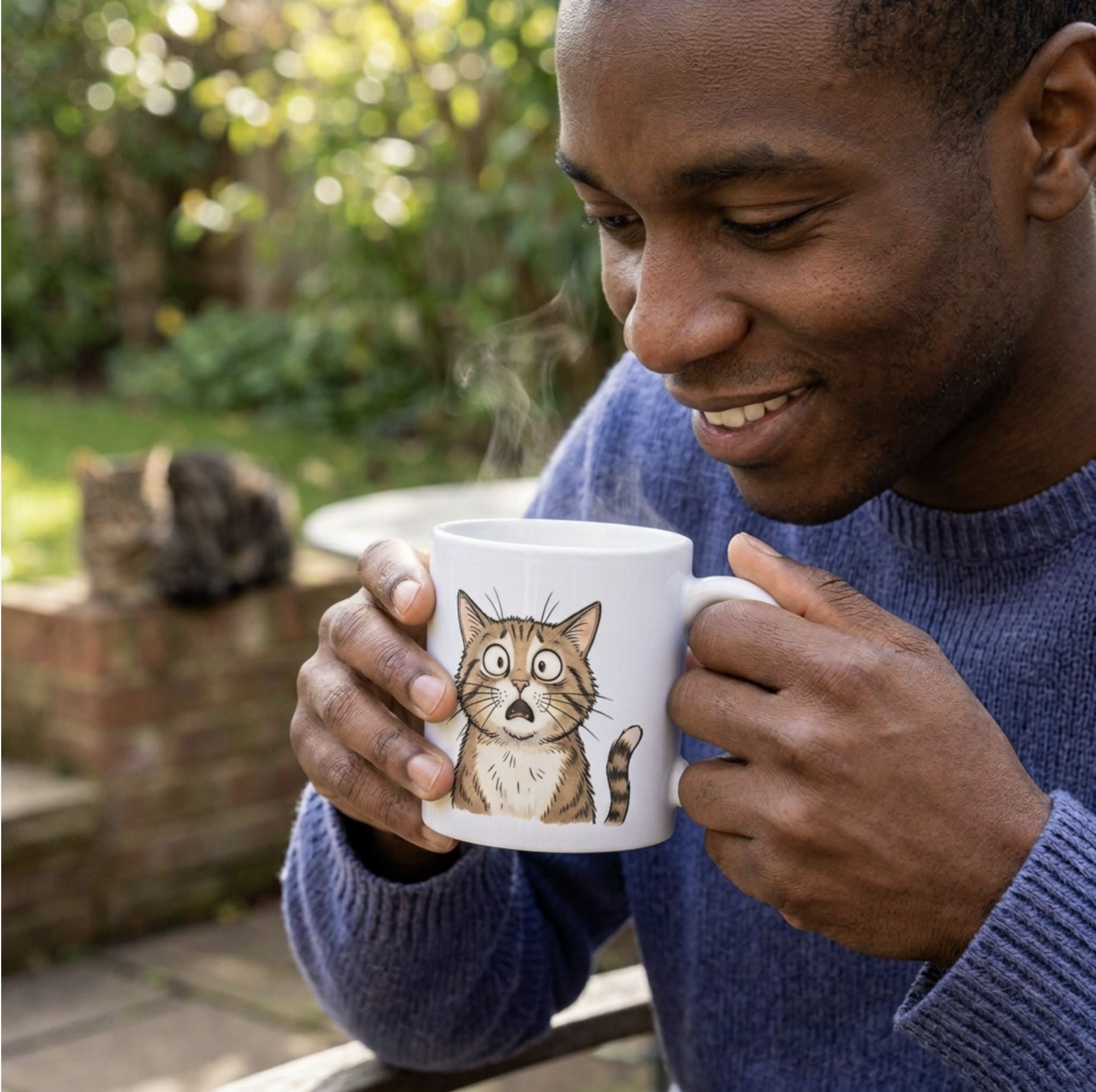 Man holding a white Frightened Feline mug of coffee outdoors in a garden.