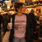 Woman at a Christmas market holding a coffee cup wearing a pink festive coffee slogan sweatshirt