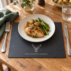 Personalised stag slate placemat under a dinner plate with a knife and fork