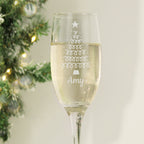 Personalised Christmas tree champagne flute with a name, beside a Christmas tree