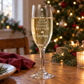 Personalised Christmas tree champagne flute with a name, beside a Christmas tree