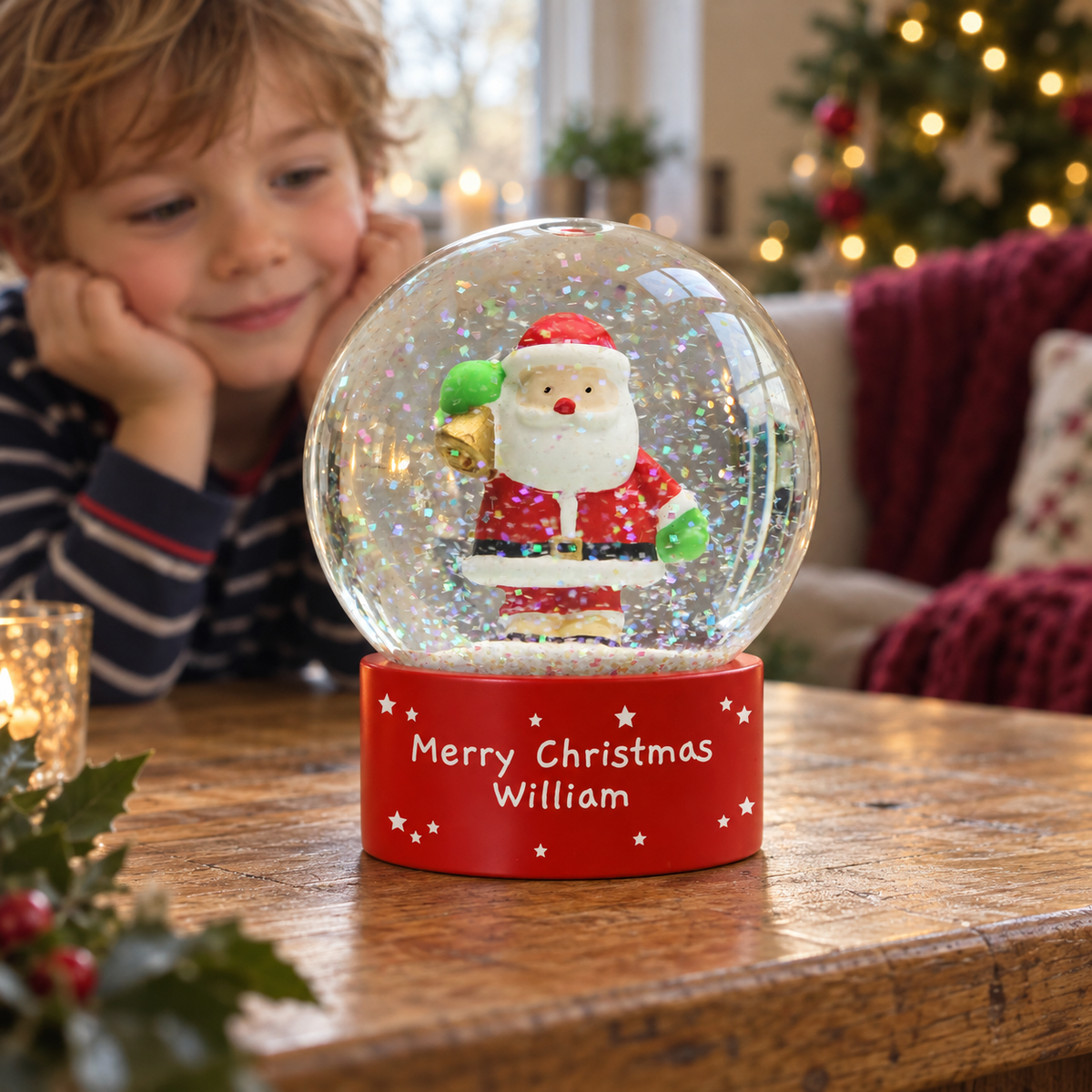 Child smiling at the Personalised Santa Snow Globe on a table