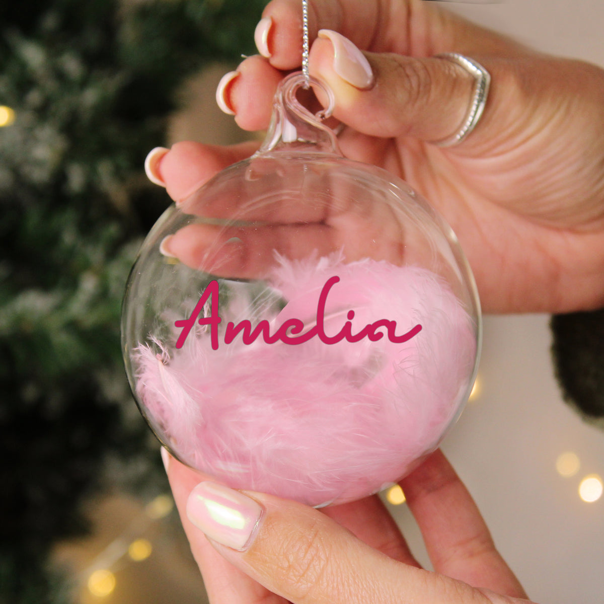 Personalised Pink Feather Glass Bauble hanging on a Christmas tree