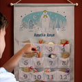 Personalised The Snowman and the Snowdog Silver Grey Advent Calendar hanging on the wall at Christmas