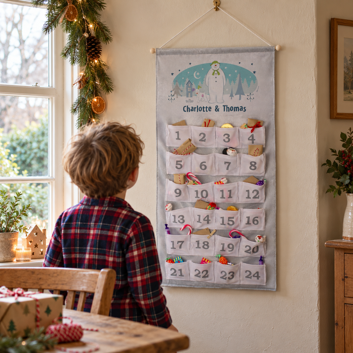 Child looking at the Personalised Snowman and the Snowdog Advent Calendar on the wall