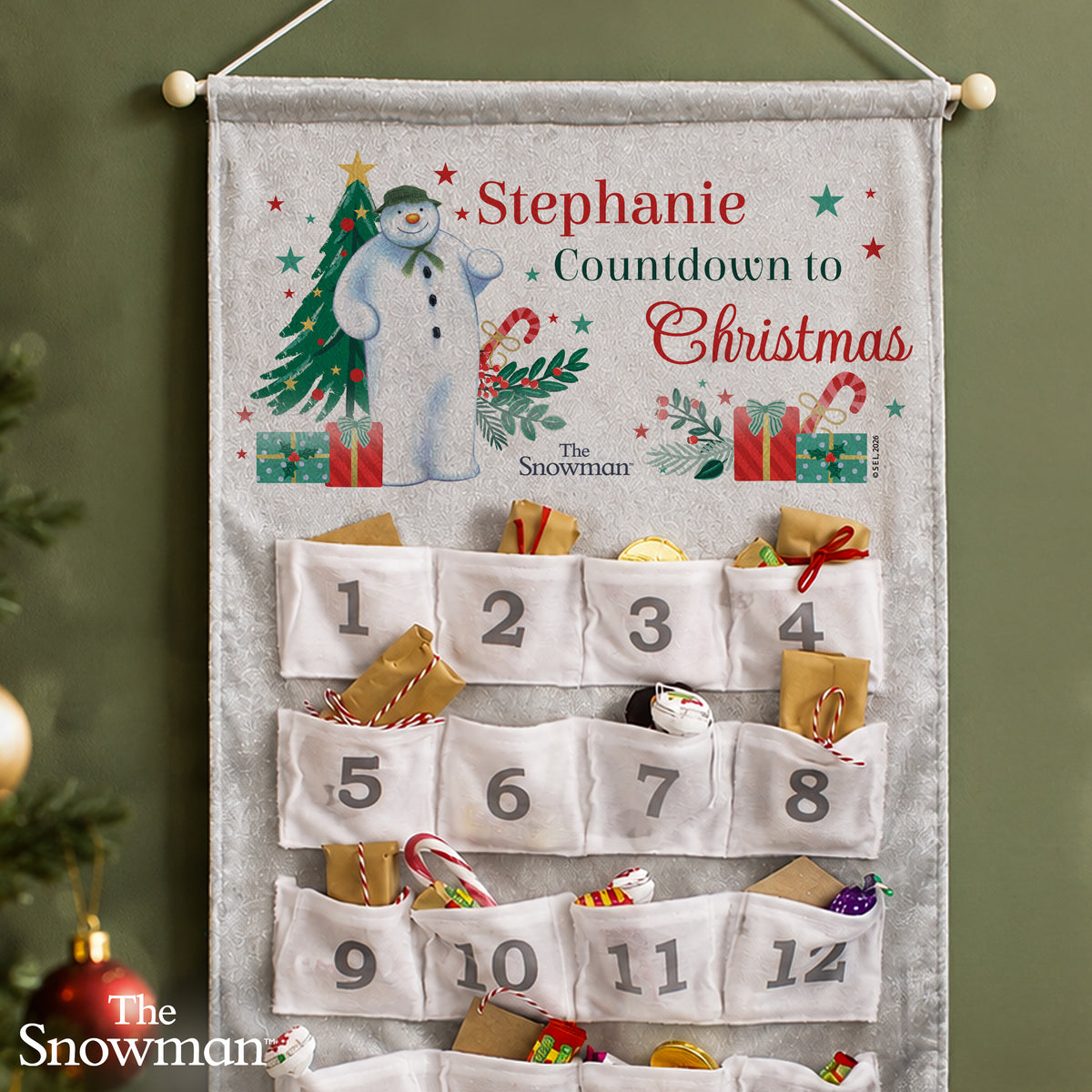 Personalised The Snowman Christmas Wishes Advent Calendar hanging on the wall at Christmas