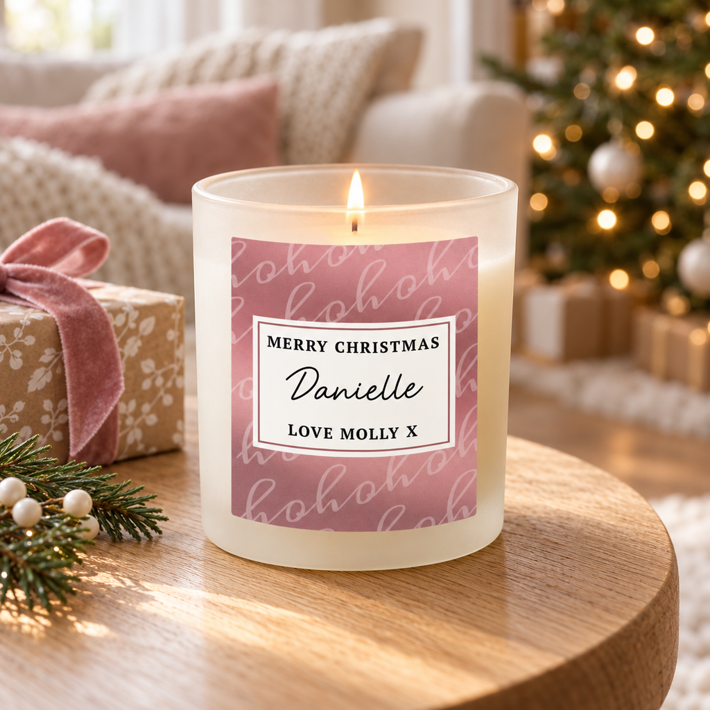 Personalised Ho Ho Ho Christmas candle jar with a dusky pink label on a wooden shelf