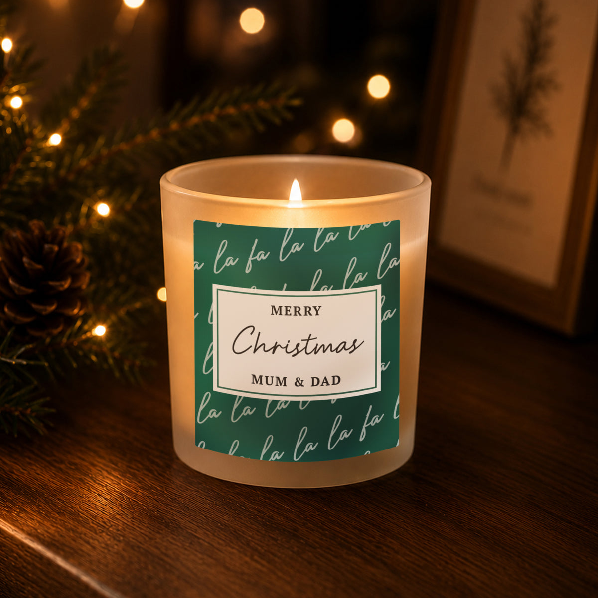 Personalised Fa La La Christmas Candle Jar glowing on a side table