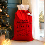 Personalised Special Delivery Red Christmas Sack beside the Christmas tree