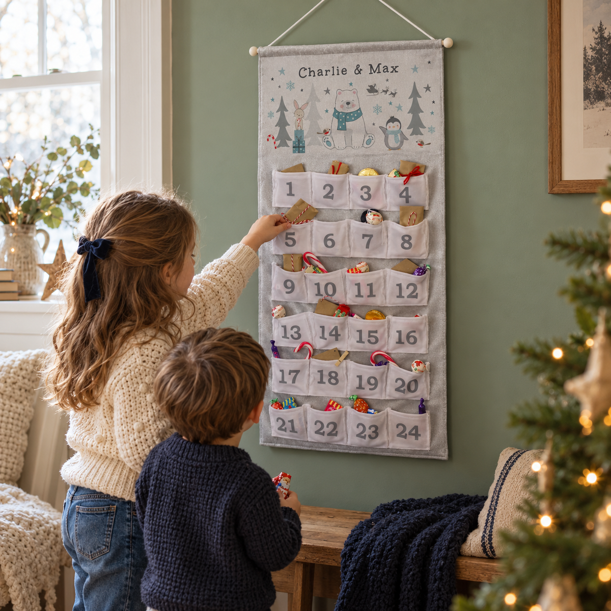 Two children opening the Personalised Polar Bear Advent Calendar by the Christmas tree