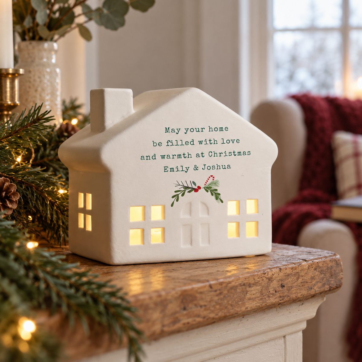 Personalised Christmas Ceramic LED House glowing on a wooden mantelpiece