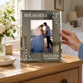 Personalised Mr & Mrs Diamante Glass Photo Frame with a wedding photo on a bedside table