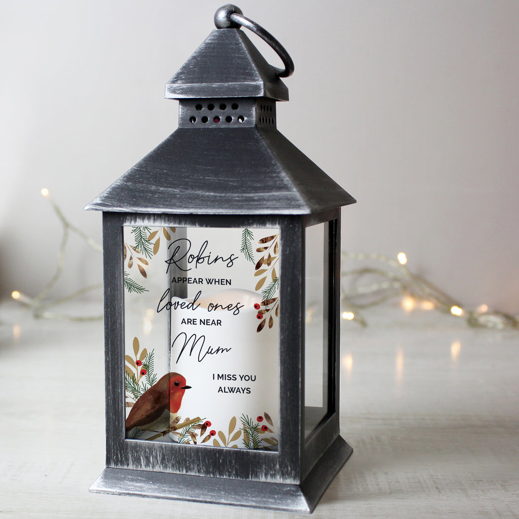 Personalised Robins Appear memorial black lantern glowing beside a Christmas tree