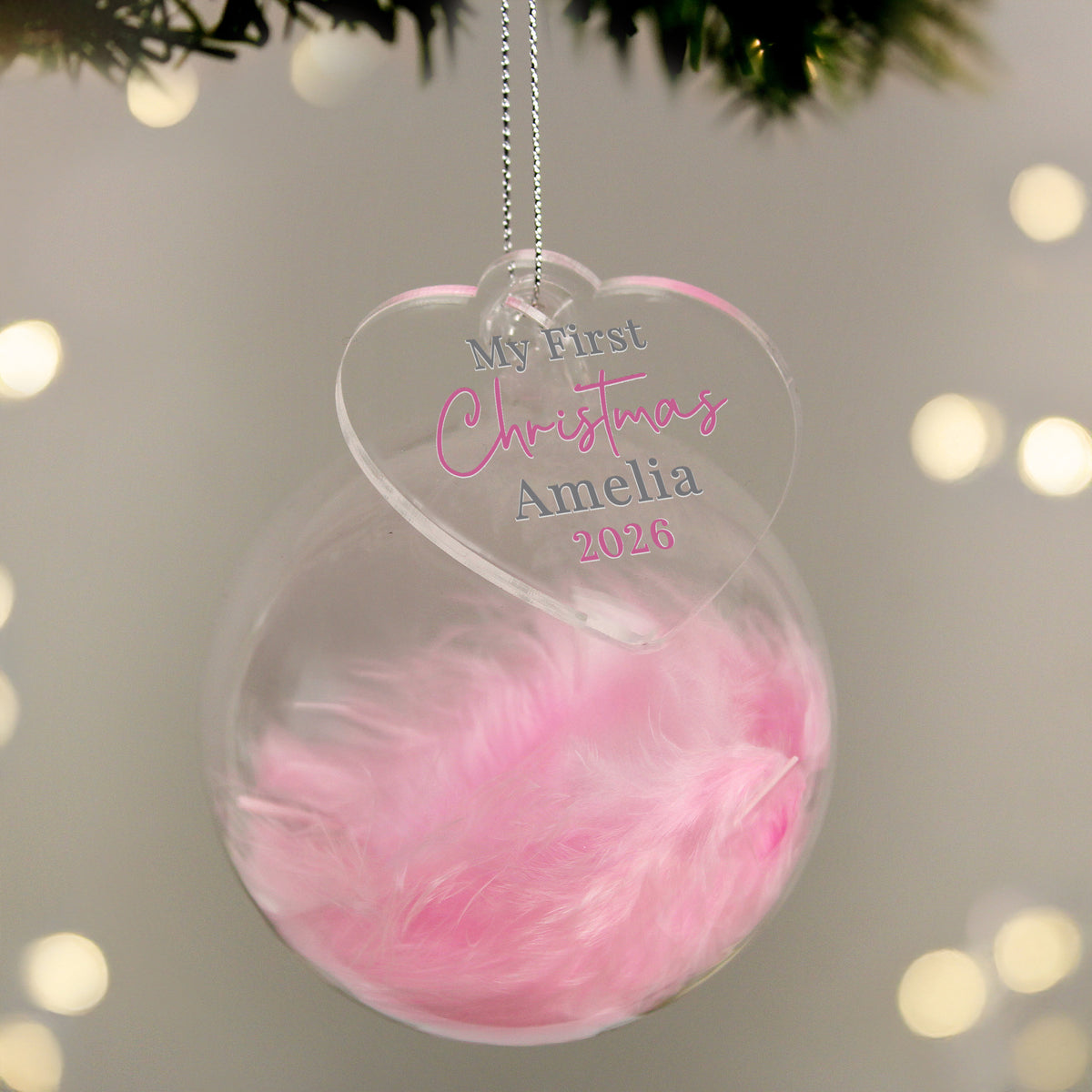 Personalised My First Christmas pink feather glass bauble hanging on the tree
