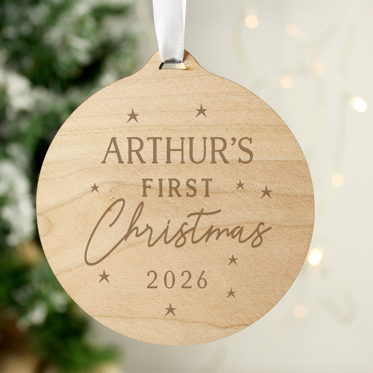 Personalised Baby's First Christmas round wooden decoration hanging on the tree