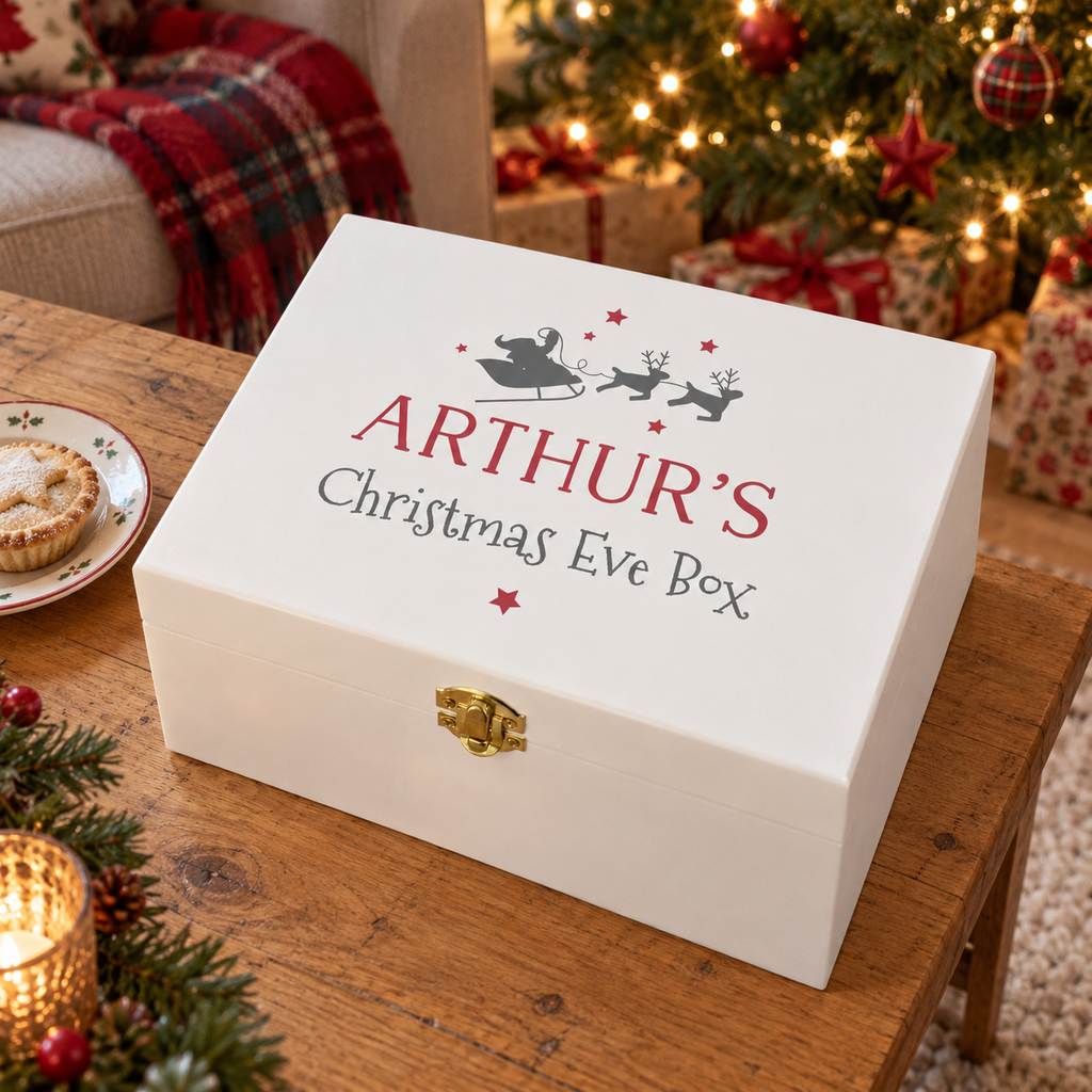 Personalised white wooden Santa sleigh Christmas Eve box on a coffee table by the tree
